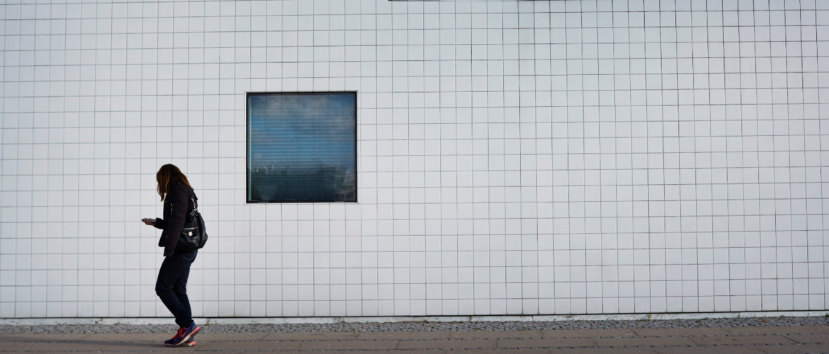 A dementia sufferer walking next to a white building